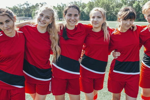Portrait of smiling soccer team standing on field - FSIF01743