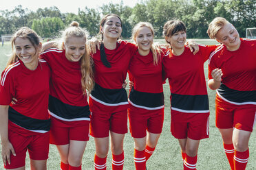 Cheerful soccer team standing on field - FSIF01749