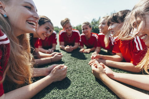 Close-up of sports team lying on playing field stock photo