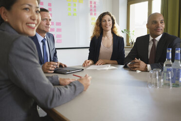 Smiling business people sitting in meeting at conference room - FSIF01758