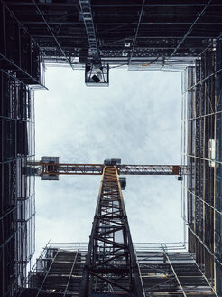Directly below shot of crane amidst glass building against sky - FSIF01803