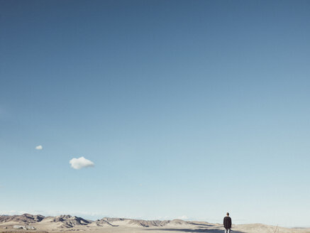 Rückansicht eines Mannes, der in einer kargen Landschaft vor blauem Himmel steht, San Bernardino, Kalifornien, USA - FSIF01809