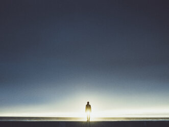 Silhouette man standing on seashore against clear sky during sunny day - FSIF01810