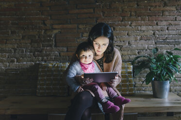 Mutter und Tochter nutzen ein digitales Tablet zu Hause - GEMF01883