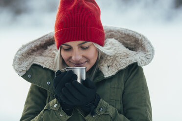 Close-up of young woman having coffee while during winter - FSIF01856