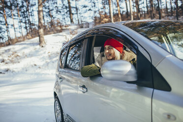 Glückliche junge Frau im Auto im Winter - FSIF01857