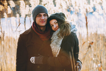 Young couple embracing while standing on field - FSIF01860