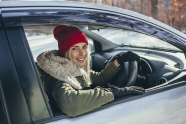Porträt einer glücklichen schönen Frau beim Autofahren im Winter - FSIF01867