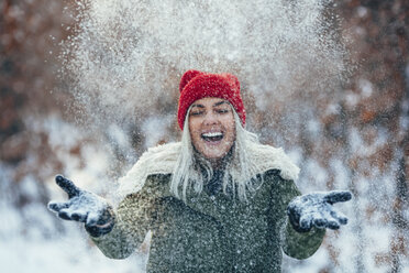 Happy young woman playing in snow - FSIF01868