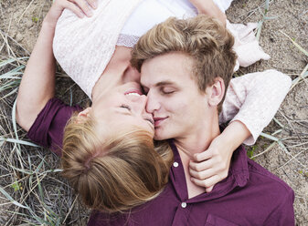 High angle view of young couple while lying on field - FSIF01885