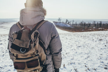 Rückansicht eines Wanderers, der auf einer verschneiten Landschaft steht - FSIF01888