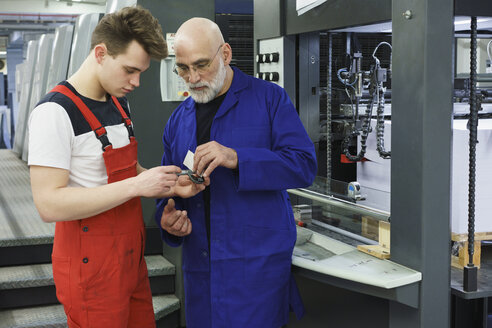 Stehender Arbeiter mit Handwerkzeug an der Druckmaschine - FSIF01918