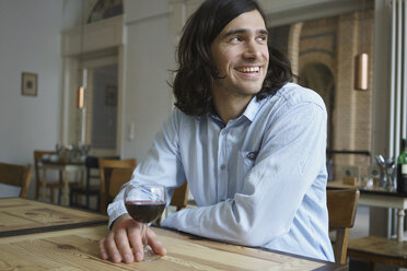 Glücklicher Mann, der Wein trinkt, während er im Café sitzt - FSIF01935