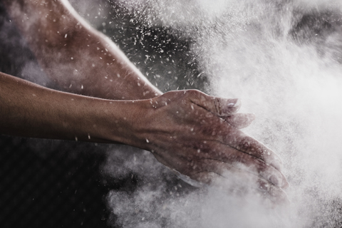 Beschnittenes Bild einer Frauenhand, die Kreidepulver für den Sport abstreut, lizenzfreies Stockfoto