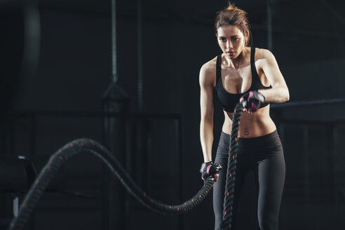 Junge Frau trainiert mit Seil im Fitnessstudio - FSIF01942