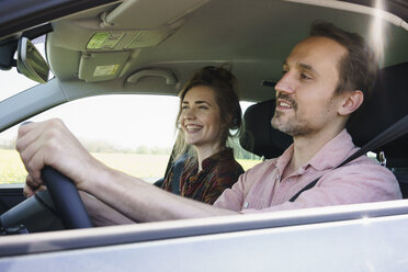 Happy man driving while sitting besides woman in car - FSIF01981