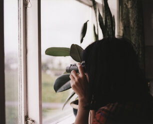 A woman looking out the window through binoculars - FSIF01990