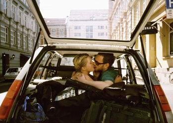 Ein Mann und eine Frau, die sich auf dem Rücksitz eines Autos küssen - FSIF01994