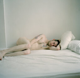 Man lying naked on bed - FSIF02047