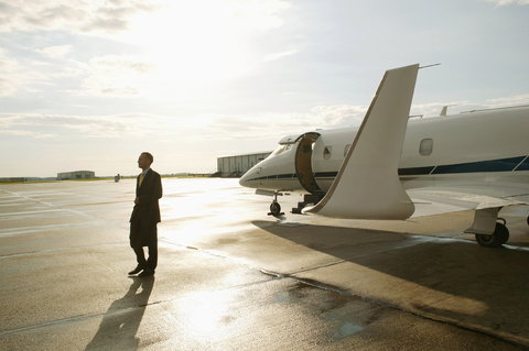Geschäftsmann beim Aussteigen aus einem Privatflugzeug, lizenzfreies Stockfoto