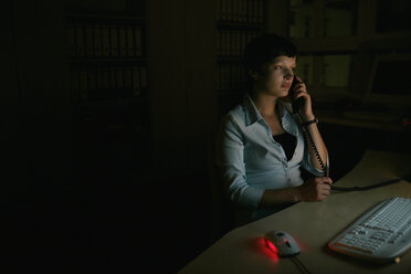 Frau am Telefon, sitzend am Schreibtisch - FSIF02050