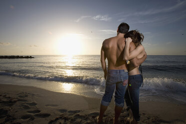 Paar umarmt am Strand bei Sonnenuntergang - FSIF02087