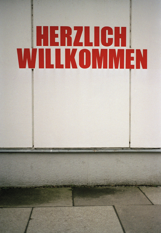 ËHerzlich Willkommení Schild an der Außenseite des Gebäudes, lizenzfreies Stockfoto