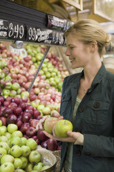 Woman choosing apples in a supermarket - FSIF02099