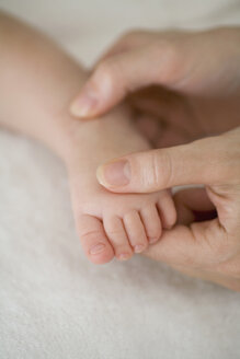 Mutter berührt den Fuß des Babys - FSIF02149
