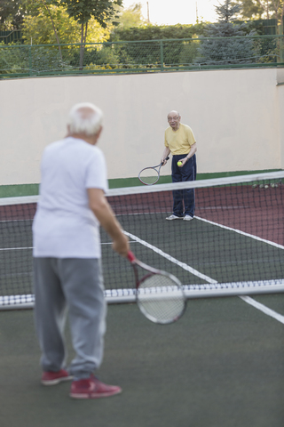 Ältere Männer spielen Tennis auf dem Platz, lizenzfreies Stockfoto