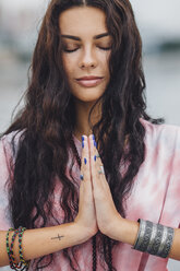 Junge Frau mit geschlossenen Augen übt Yoga in Gebetshaltung - FSIF02181