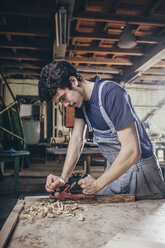 Schreiner hobelt Holz in der Werkstatt - FSIF02253