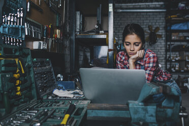 Mechanikerin mit Laptop in der Werkstatt - FSIF02271