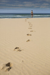 Mid distance of woman at beach against sky - FSIF02296