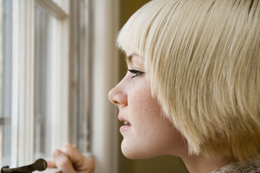 Young woman looking out a window - FSIF02340