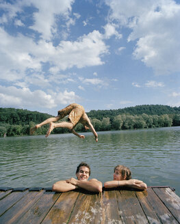 Ein junger Mann taucht mit Freunden in einen See - FSIF02363