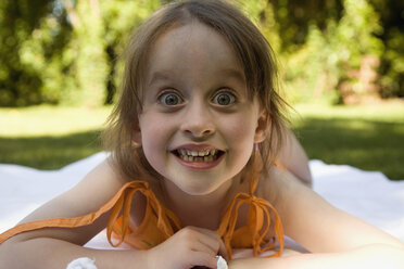 Young girl lying down on a blanket in a backyard - FSIF02372