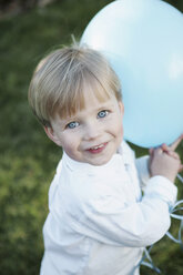 Junge hält einen blauen Luftballon - FSIF02381