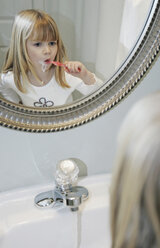 Young girl brushing her teeth in a bathroom - FSIF02382