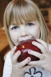 A young girl eating a red apple - FSIF02385