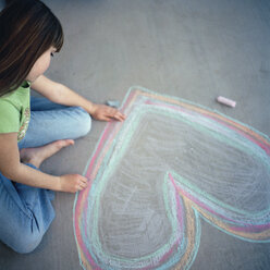 Junges Mädchen zeichnet ein Herz mit Kreide - FSIF02394
