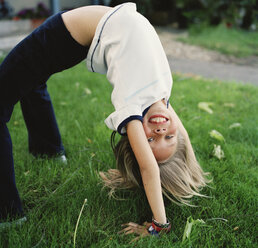 Mädchen übt Gymnastik im Garten - FSIF02398