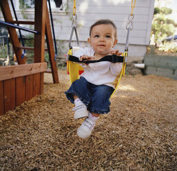 Baby girl sitting in a swing - FSIF02402