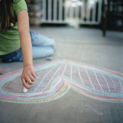 Junges Mädchen zeichnet ein Herz mit Kreide - FSIF02403