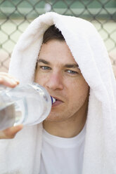Ein Mann trinkt aus einer Wasserflasche - FSIF02421