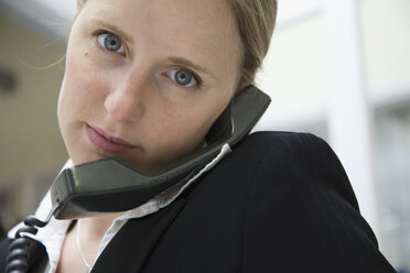 Eine Frau benutzt ein Festnetztelefon - FSIF02466