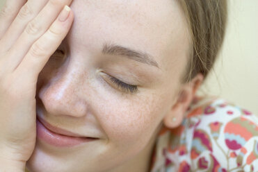 A young woman with her eyes closed and hand over her face - FSIF02477