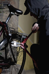 Ein vermummter Mann schneidet ein Fahrradschloss mit einem Bolzenschneider auf - FSIF02479