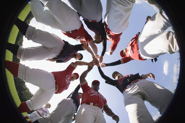 A baseball team with their hands stacked together in a huddle - FSIF02493