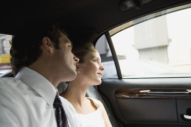 Braut und Bräutigam schauen aus dem Autofenster - FSIF02501